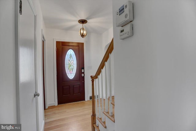 entrance foyer with light wood-type flooring and a notable chandelier