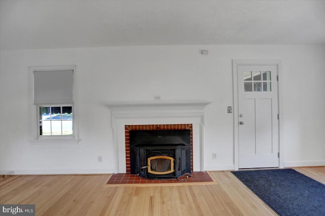 unfurnished living room with a wood stove and hardwood / wood-style flooring