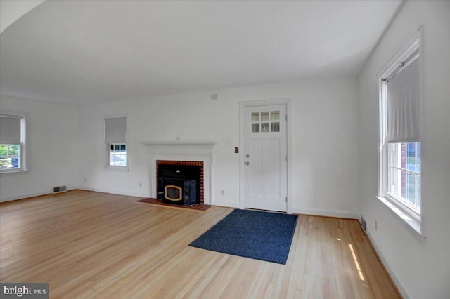 unfurnished living room with light wood-type flooring and a healthy amount of sunlight