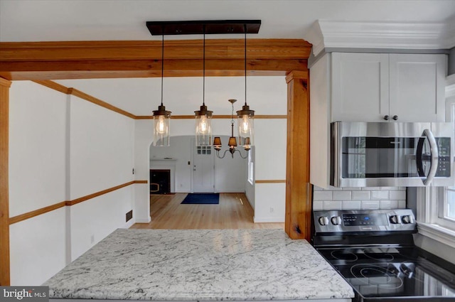 kitchen featuring white cabinets, light hardwood / wood-style floors, hanging light fixtures, light stone counters, and electric range