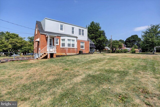 view of front of home with a front yard and central AC unit