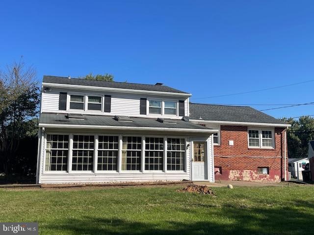 rear view of property with a yard