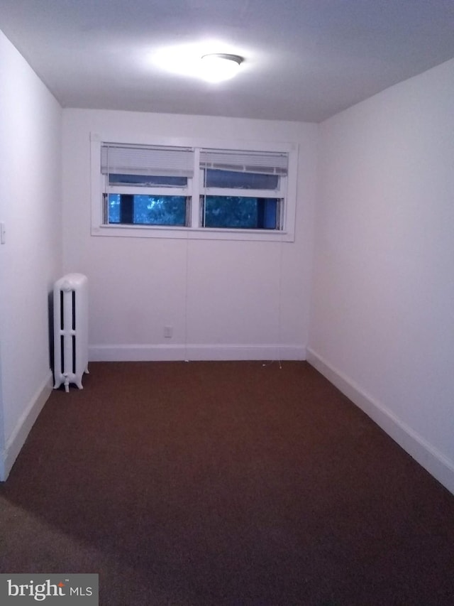 carpeted empty room with radiator heating unit