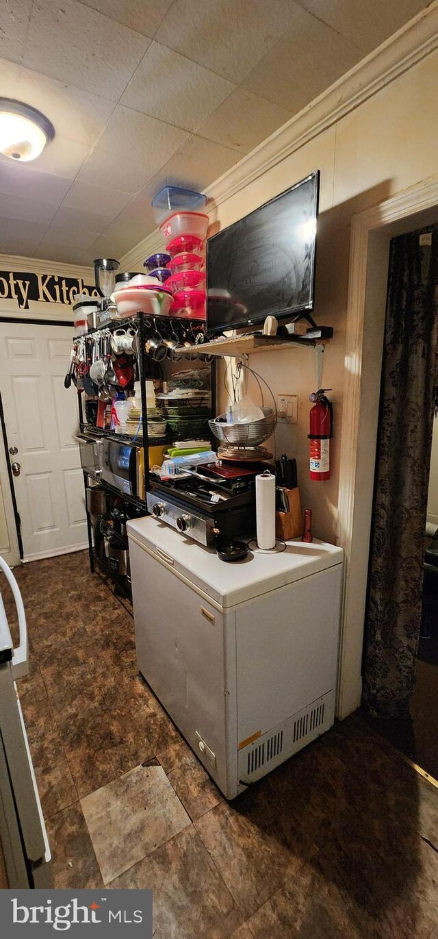 kitchen with decorative backsplash, crown molding, and electric range