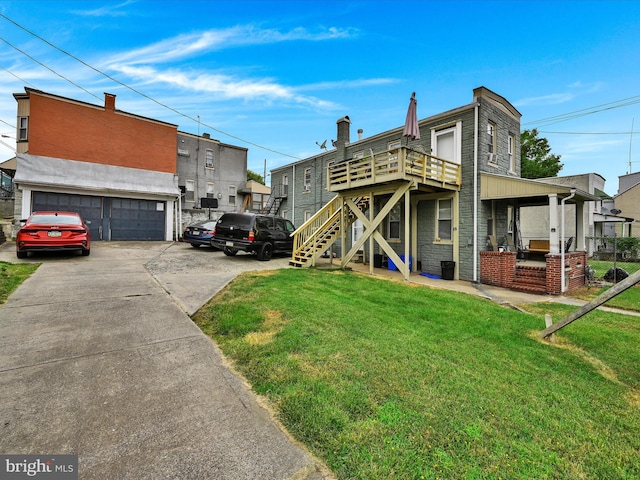 back of property featuring a garage and a yard