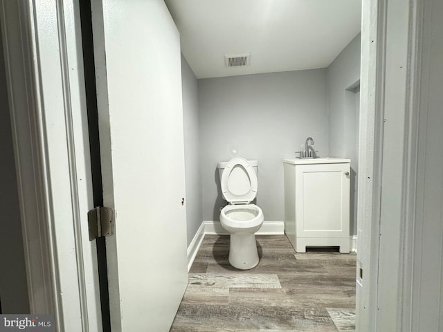 bathroom featuring hardwood / wood-style floors, vanity, and toilet