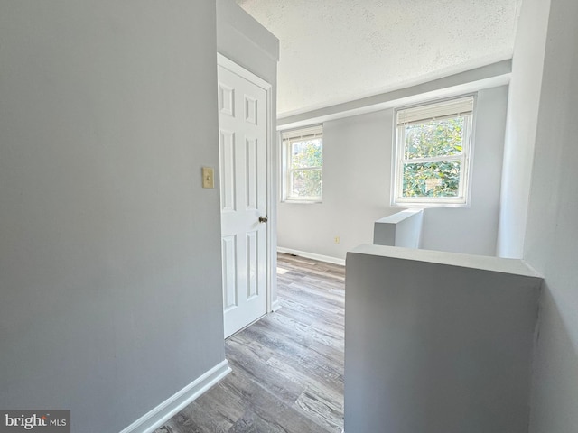 corridor featuring a textured ceiling and hardwood / wood-style flooring