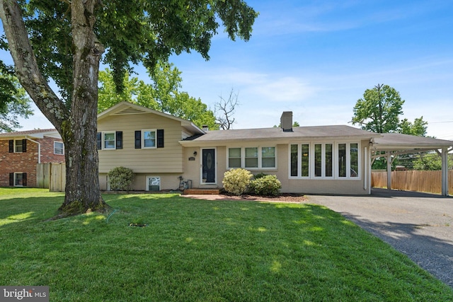 tri-level home featuring a front lawn and a carport