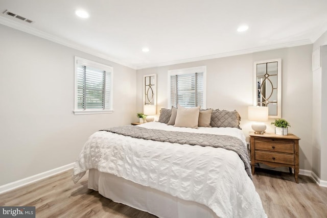 bedroom featuring crown molding and light hardwood / wood-style floors