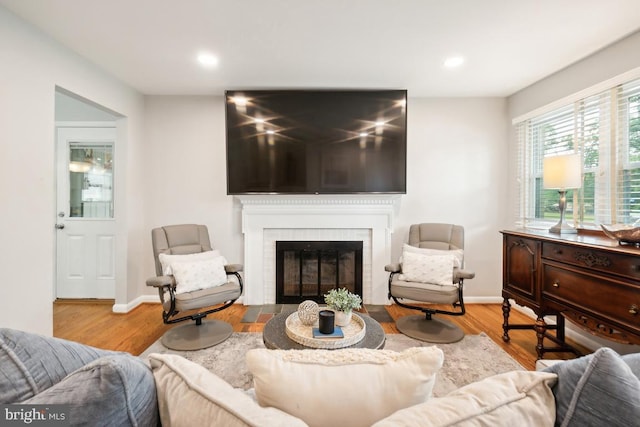 living room featuring light wood-type flooring and a brick fireplace