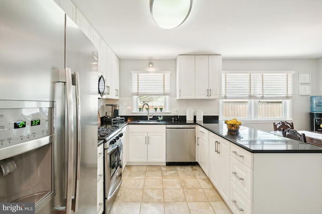 kitchen featuring white cabinetry, sink, stainless steel appliances, tasteful backsplash, and kitchen peninsula