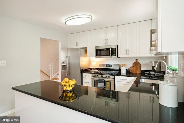 kitchen featuring kitchen peninsula, appliances with stainless steel finishes, tasteful backsplash, sink, and white cabinetry