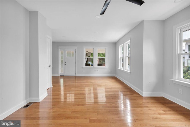 unfurnished living room featuring a healthy amount of sunlight, light hardwood / wood-style flooring, and ceiling fan