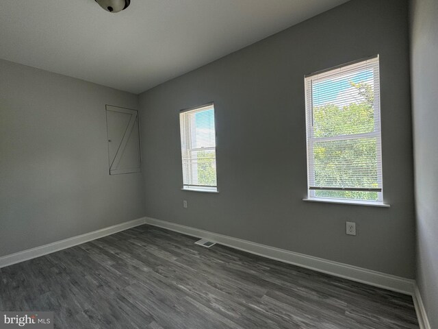 spare room with a wealth of natural light and hardwood / wood-style floors