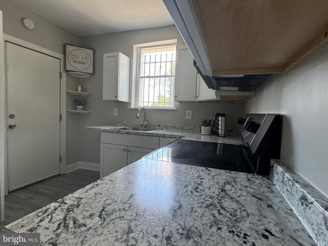 kitchen with sink, range, dark hardwood / wood-style floors, and white cabinets