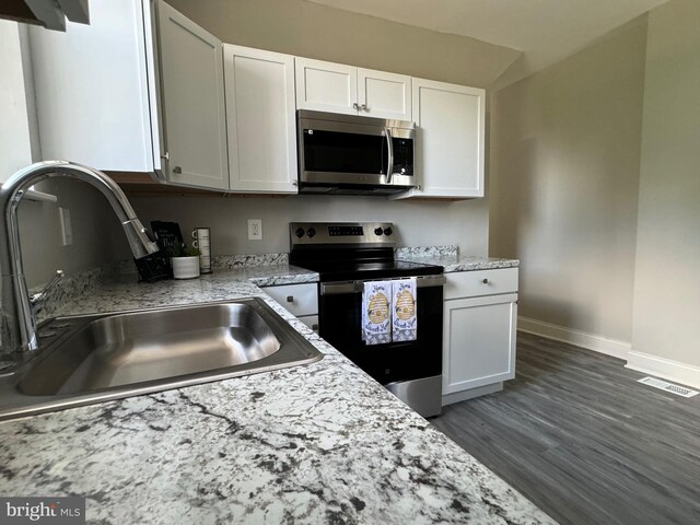 kitchen with sink, stainless steel appliances, dark wood-type flooring, and white cabinetry