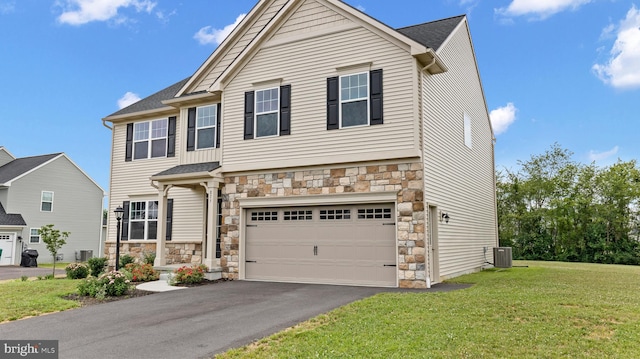 view of front facade featuring cooling unit, a garage, and a front lawn