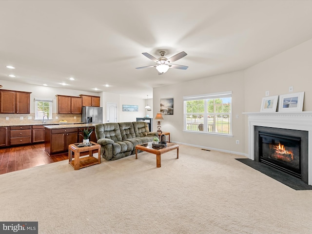 living room with carpet, ceiling fan, and sink