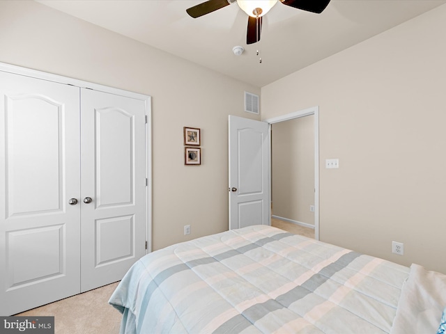 carpeted bedroom featuring ceiling fan and a closet