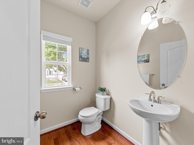 bathroom with hardwood / wood-style flooring and toilet