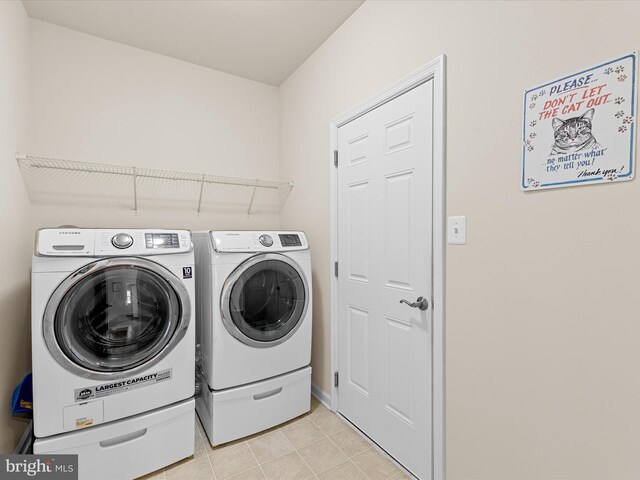 clothes washing area with washer and dryer and light tile patterned flooring