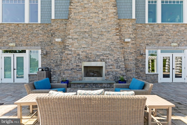 view of patio / terrace featuring french doors and an outdoor stone fireplace