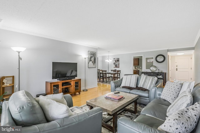 living room with an inviting chandelier, crown molding, and light hardwood / wood-style floors