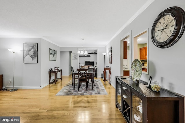 dining room with a chandelier, light hardwood / wood-style floors, and ornamental molding