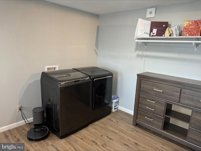 clothes washing area featuring separate washer and dryer and light wood-type flooring