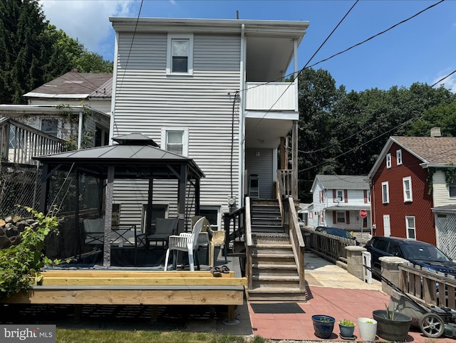 back of house with a gazebo and a deck