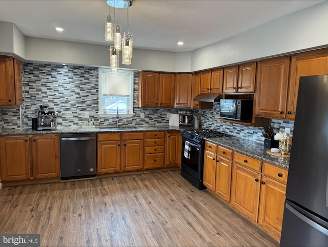 kitchen with backsplash, black appliances, and hardwood / wood-style floors