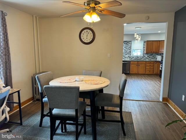 dining room with dark hardwood / wood-style flooring, sink, and ceiling fan