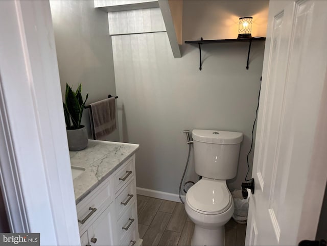 bathroom with vanity, toilet, and hardwood / wood-style flooring