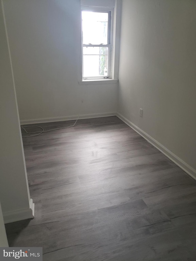 unfurnished room featuring dark wood-type flooring