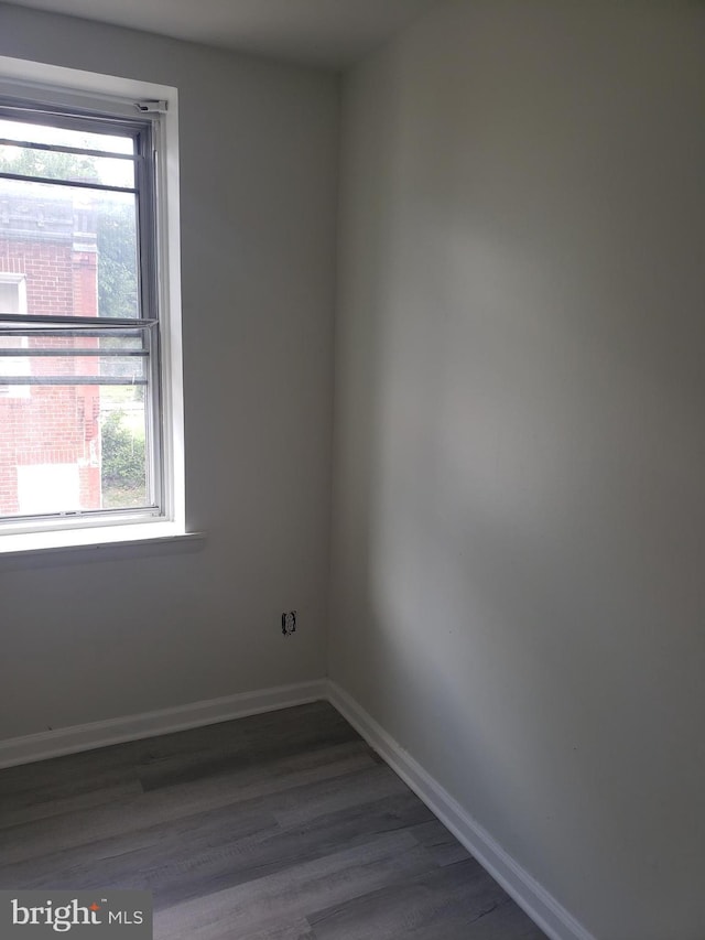 empty room featuring dark wood-type flooring and a wealth of natural light