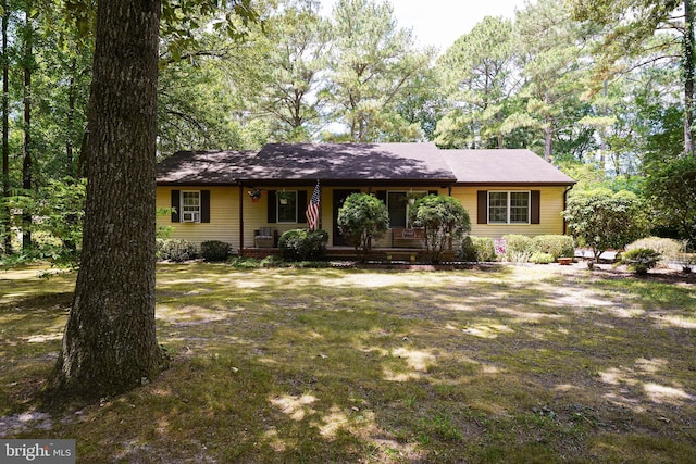 ranch-style home featuring a porch and a front yard