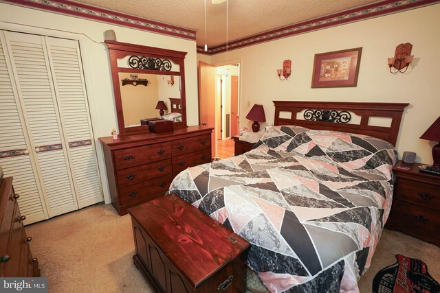 bedroom featuring crown molding, light colored carpet, a textured ceiling, and a closet