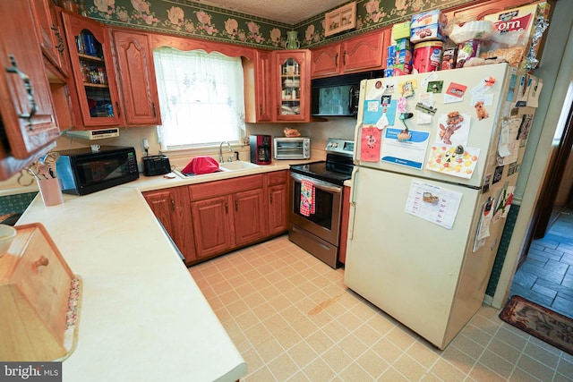 kitchen featuring white fridge, electric stove, and sink