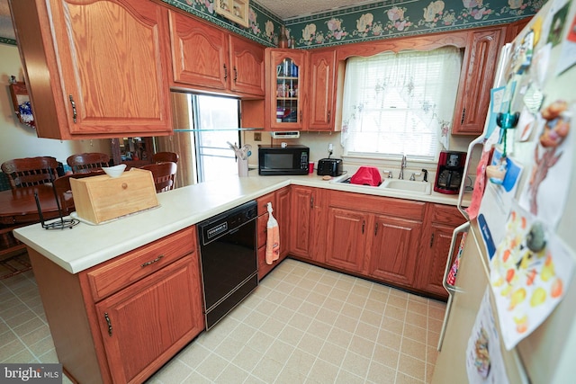 kitchen featuring kitchen peninsula, sink, and black appliances