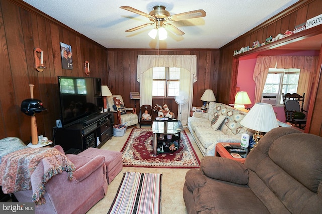 living room featuring a wealth of natural light, a textured ceiling, ceiling fan, and wood walls