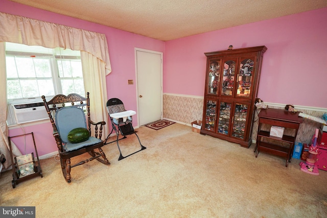 sitting room with carpet flooring, cooling unit, and a textured ceiling