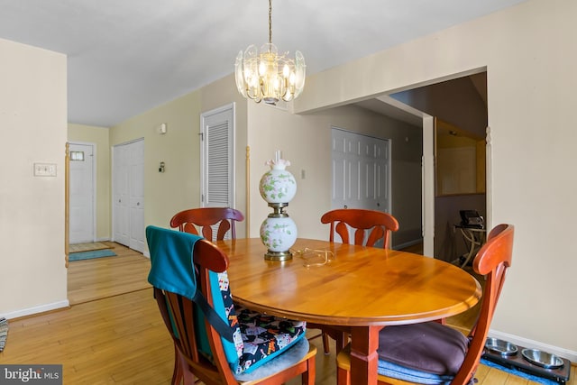 dining area with a notable chandelier and light hardwood / wood-style floors