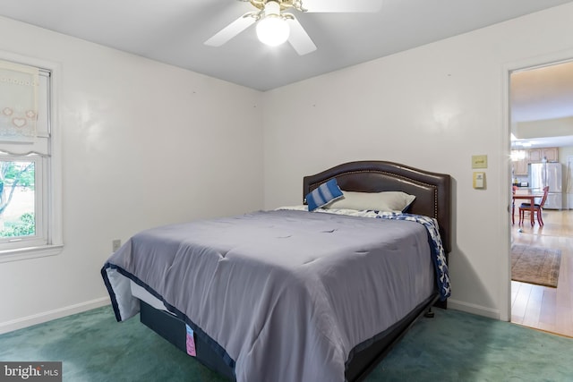 carpeted bedroom featuring ceiling fan and stainless steel fridge