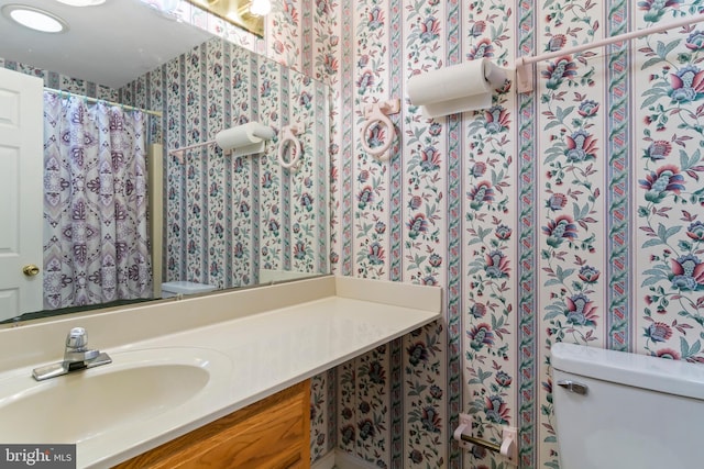 bathroom with toilet, a shower with curtain, and vanity