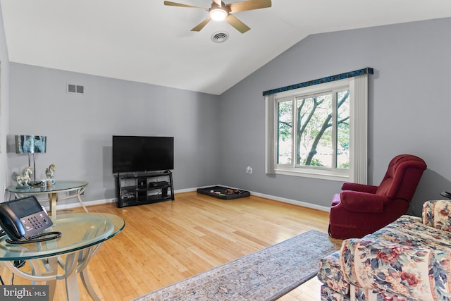 living room with ceiling fan, hardwood / wood-style floors, and vaulted ceiling