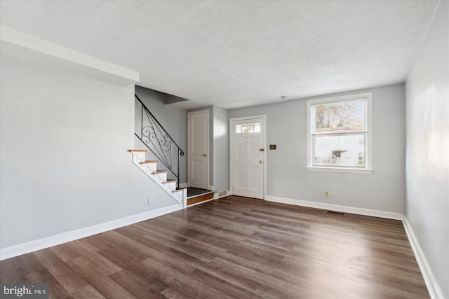 entryway featuring a textured ceiling and dark hardwood / wood-style floors