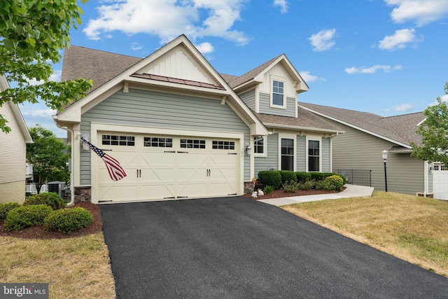 craftsman house with a front yard, a garage, and central air condition unit