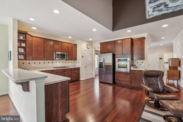 kitchen featuring stainless steel appliances, a kitchen breakfast bar, dark hardwood / wood-style floors, backsplash, and crown molding