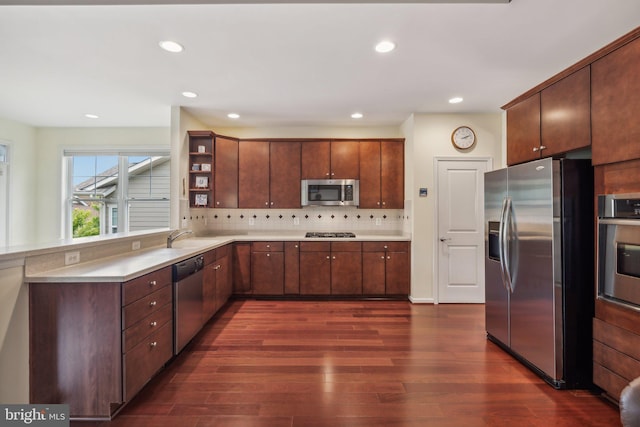 kitchen featuring backsplash, sink, stainless steel appliances, and dark wood-type flooring