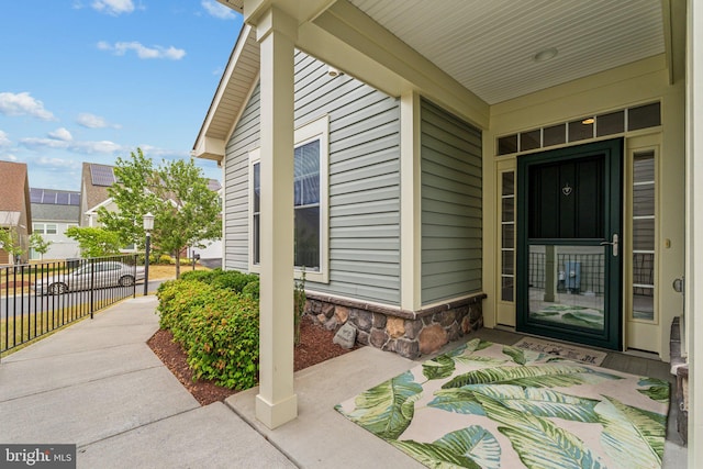 view of exterior entry featuring covered porch